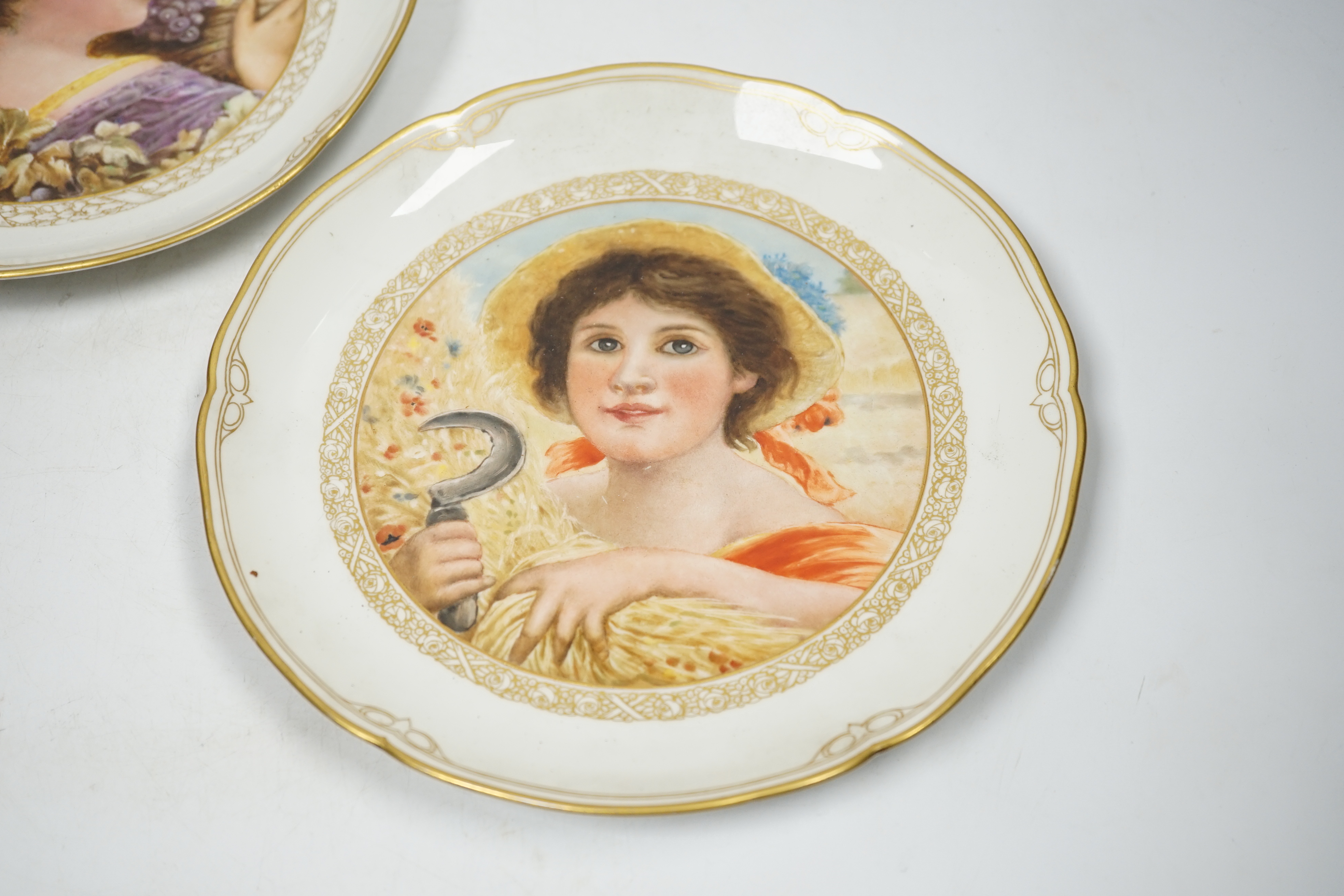 A pair of late 19th century Berlin plates, hand painted with females, 21.5cm